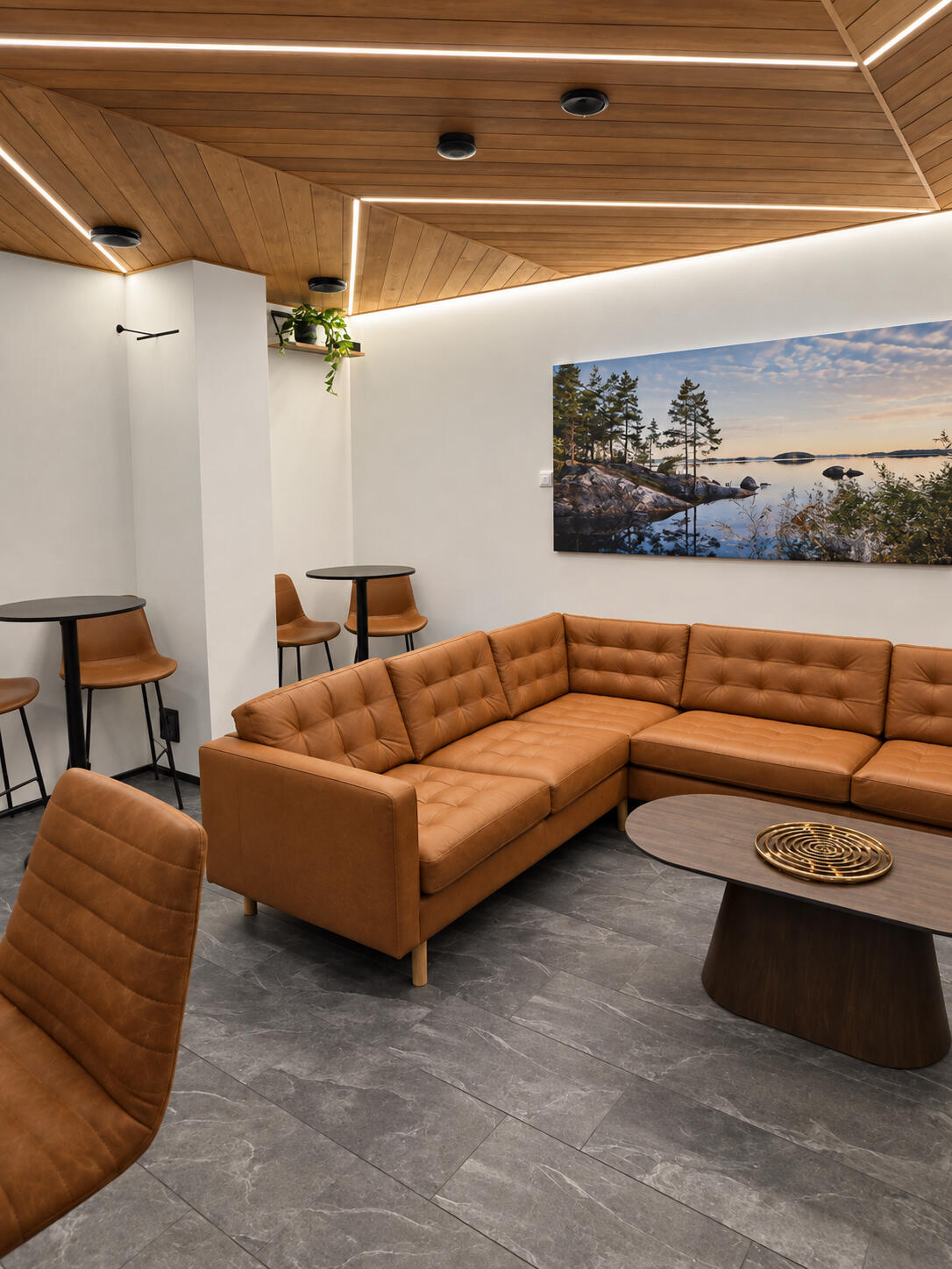 Vaaralan Saunan viihtyisä lounge kutsuu rentoutumaan löylyjen lomassa – lämmin sisustus ja mukava sohvaryhmä luovat puitteet yhteiseen saunailtaan Vantaalla.